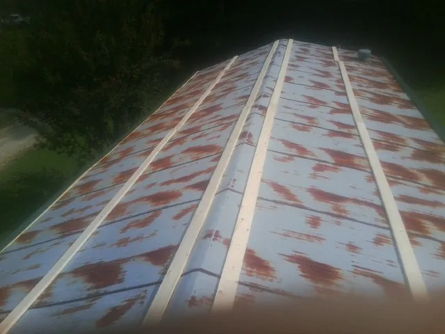 Rusted metal roof panels with new wood purlins before replacement — Storm Damage Roof Repair in Cocolamus by Roofing Brothers