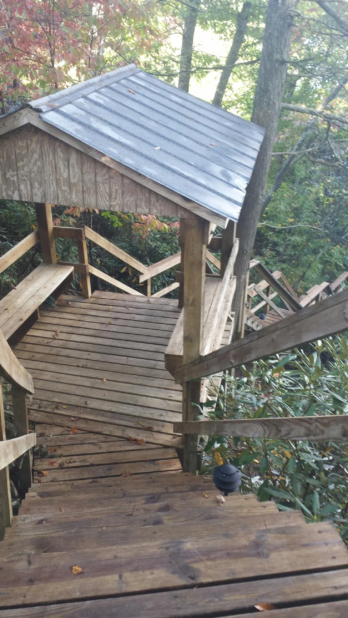 Metal roofed shelter over wooden steps on a wooded walkway — Skylight Repair & Installation work by our crew in Cocolamus